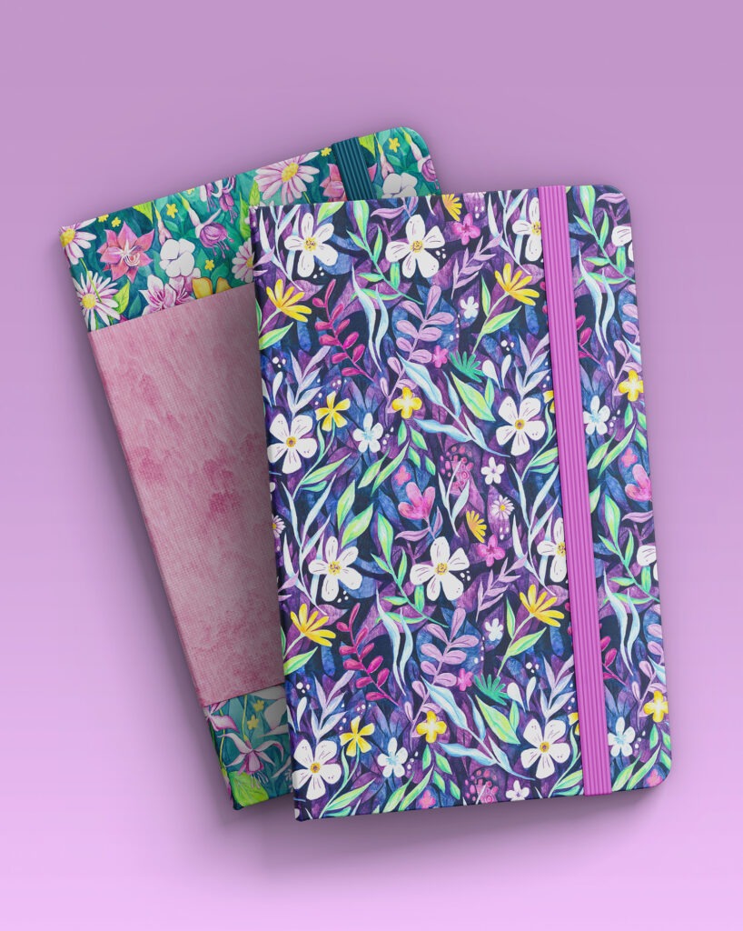 Deux carnets empilés, l’un avec un motif aquarelle mauve et l’autre avec un motif floral lumineux. L’harmonie des couleurs crée une ambiance douce et créative.