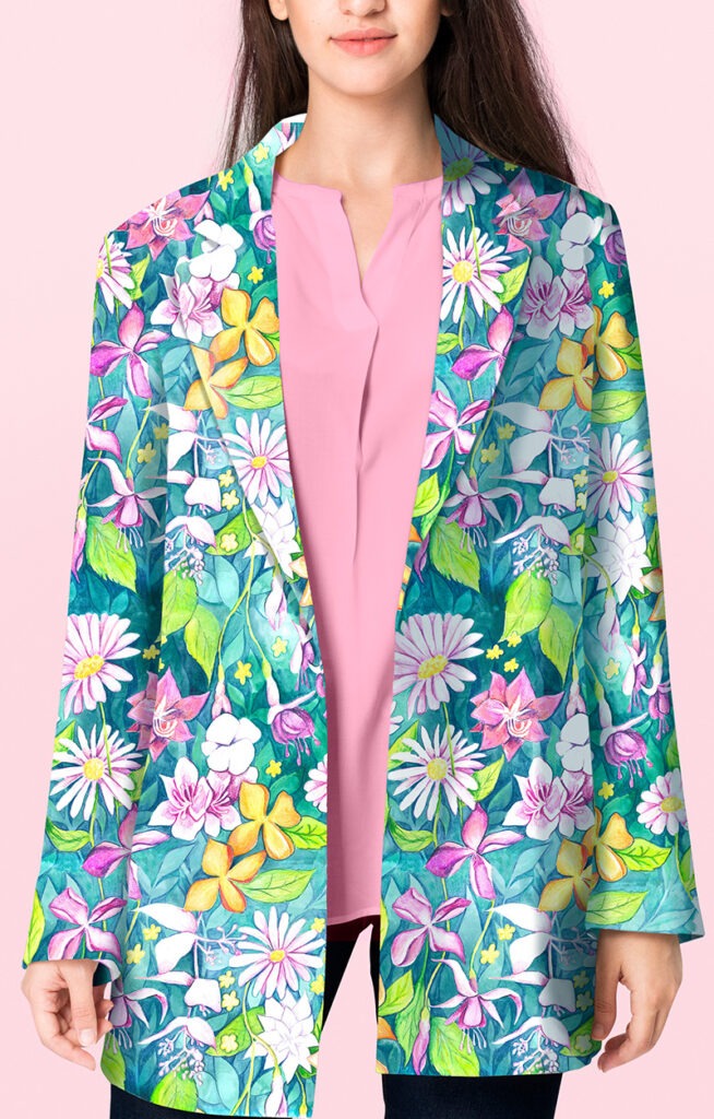 Femme portant un blazer aux motifs floraux aquarelle verts et bleus, qui apportent une touche de douceur et d'originalité au vêtement.